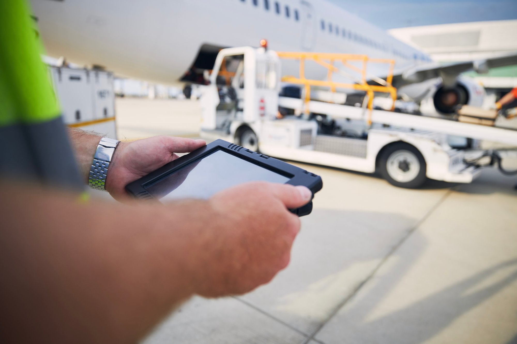 A logistics planner using a tablet beside a jet