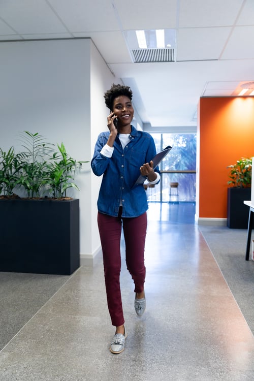 Businesswoman talking on smartphone with laptop