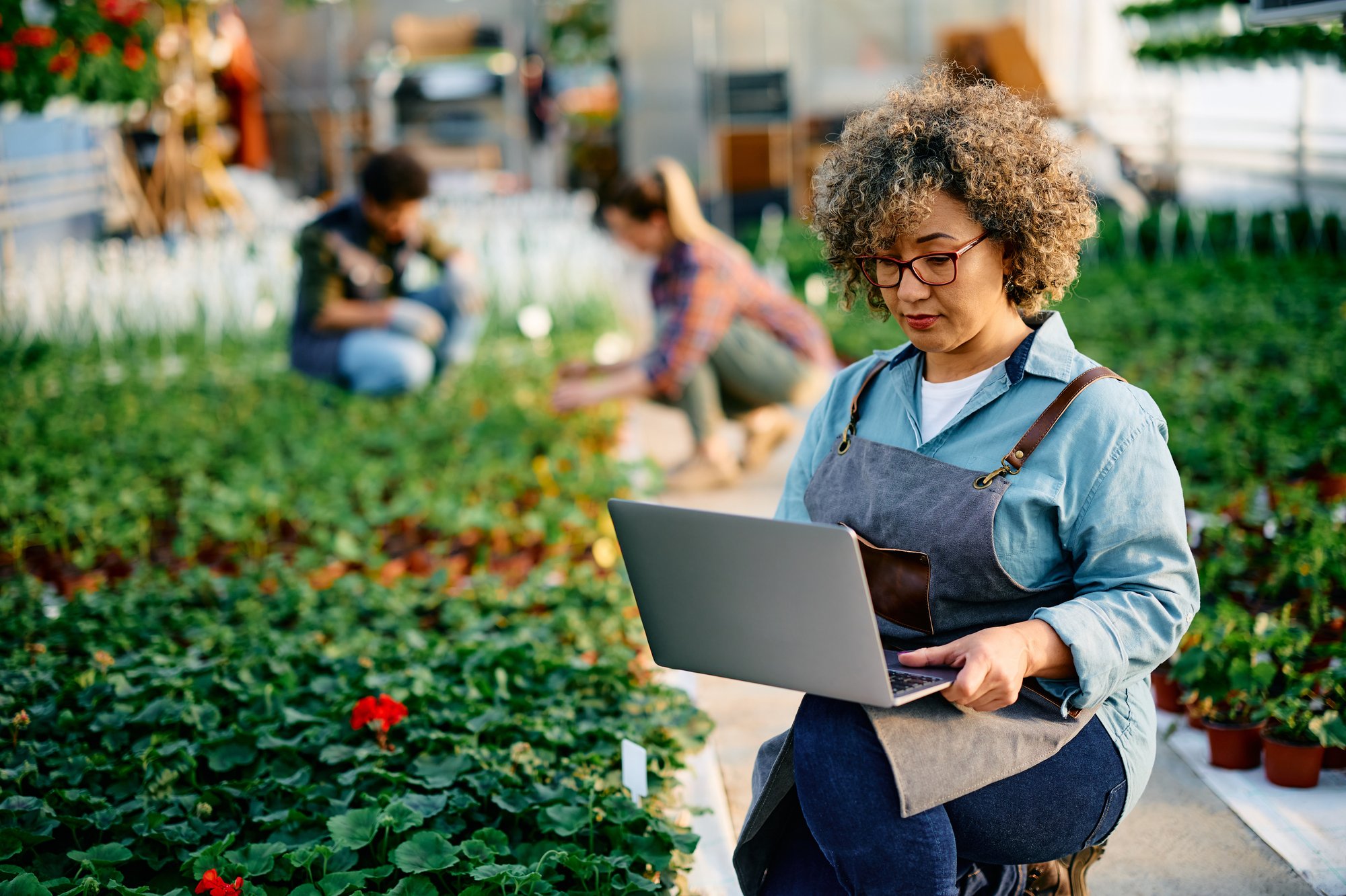 Female worker using computer at plant nursery