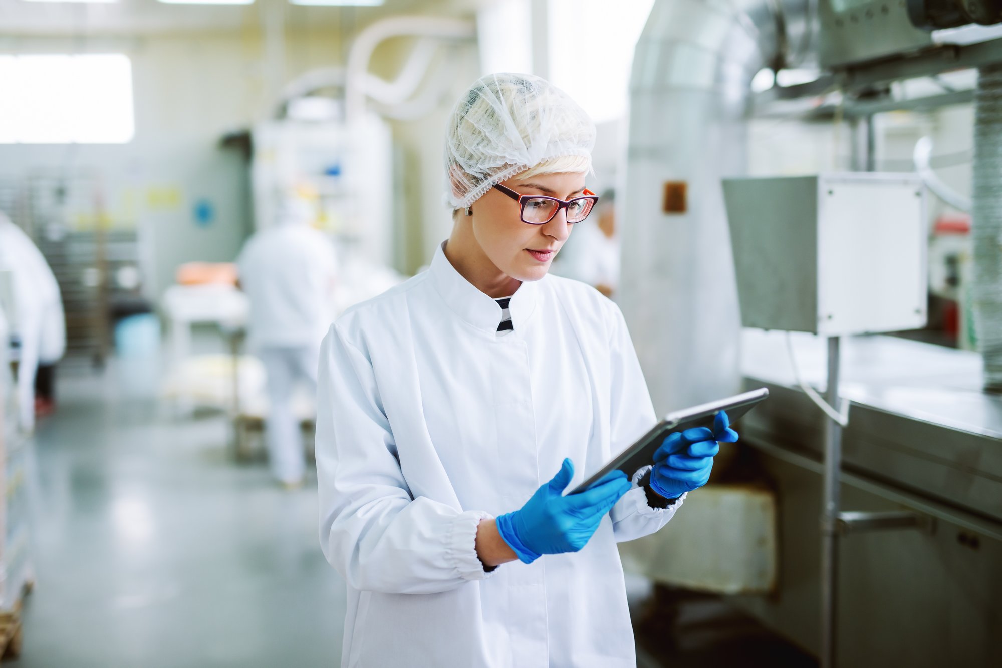 Female worker using tablet in factory