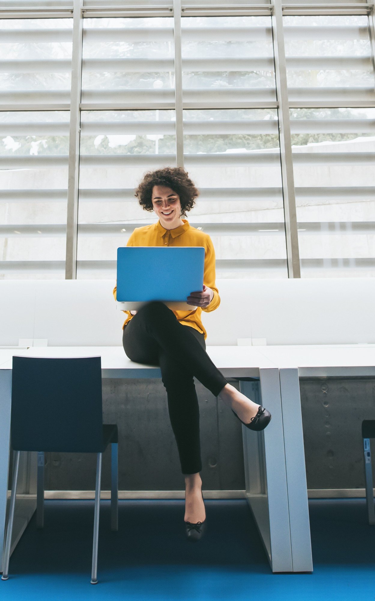 Woman using laptop yellow shirt-1